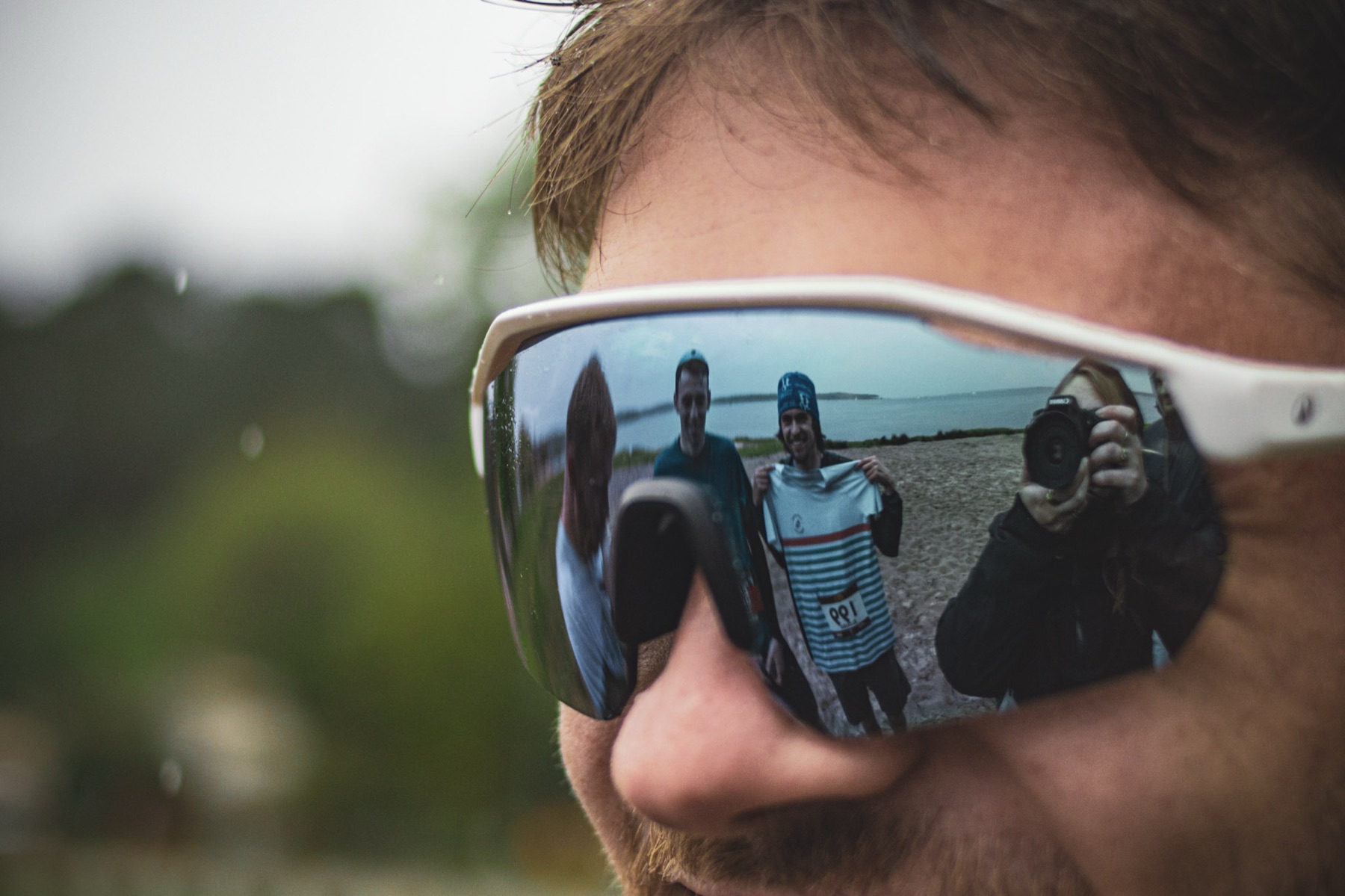 Bénévoles reflétés dans les lunettes d'un coureur
